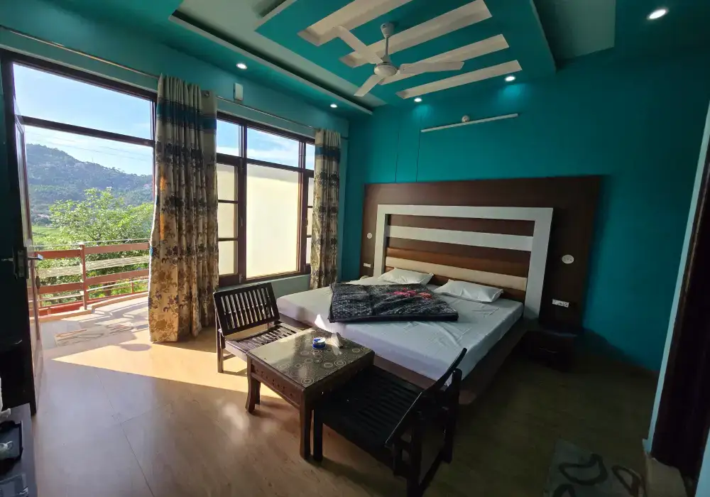 Deluxe room at JK Imperial Hotel Dalhousie with comfortable bed and mountain view